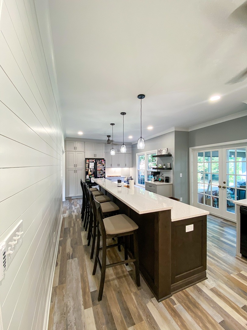 A long breakfast bar in dark stained cabinetry running the length of an open plan Nashville kitchen